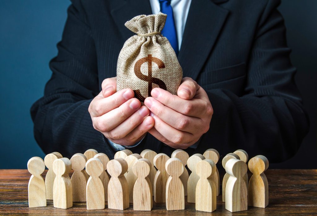 Businessman,Holds,Out,A,Dollar,Money,Bag,To,The,Crowd. Businessman,Holds,Out,A,Dollar,Money,Bag,To,The,Crowd.