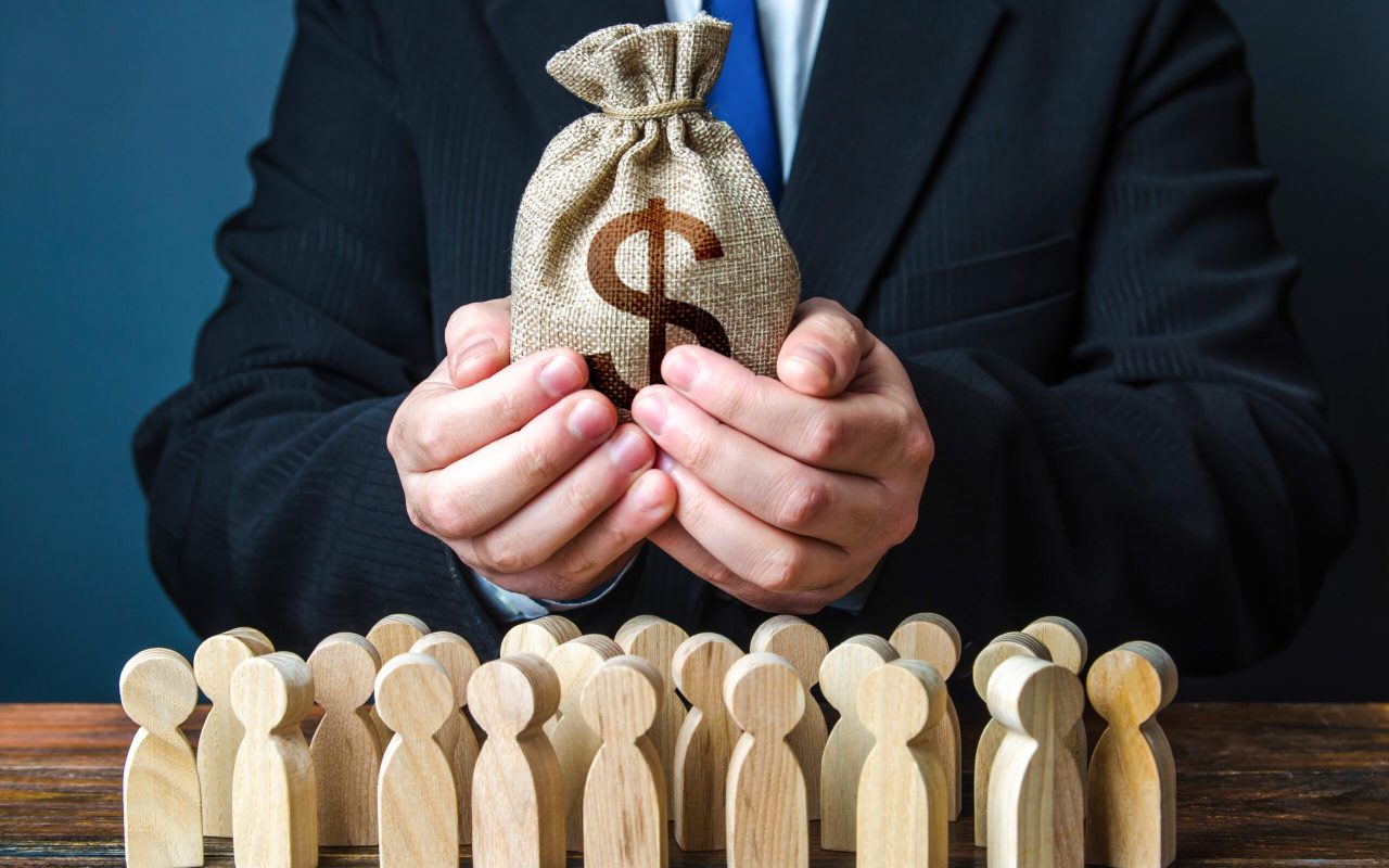 Businessman,Holds,Out,A,Dollar,Money,Bag,To,The,Crowd. Businessman,Holds,Out,A,Dollar,Money,Bag,To,The,Crowd.